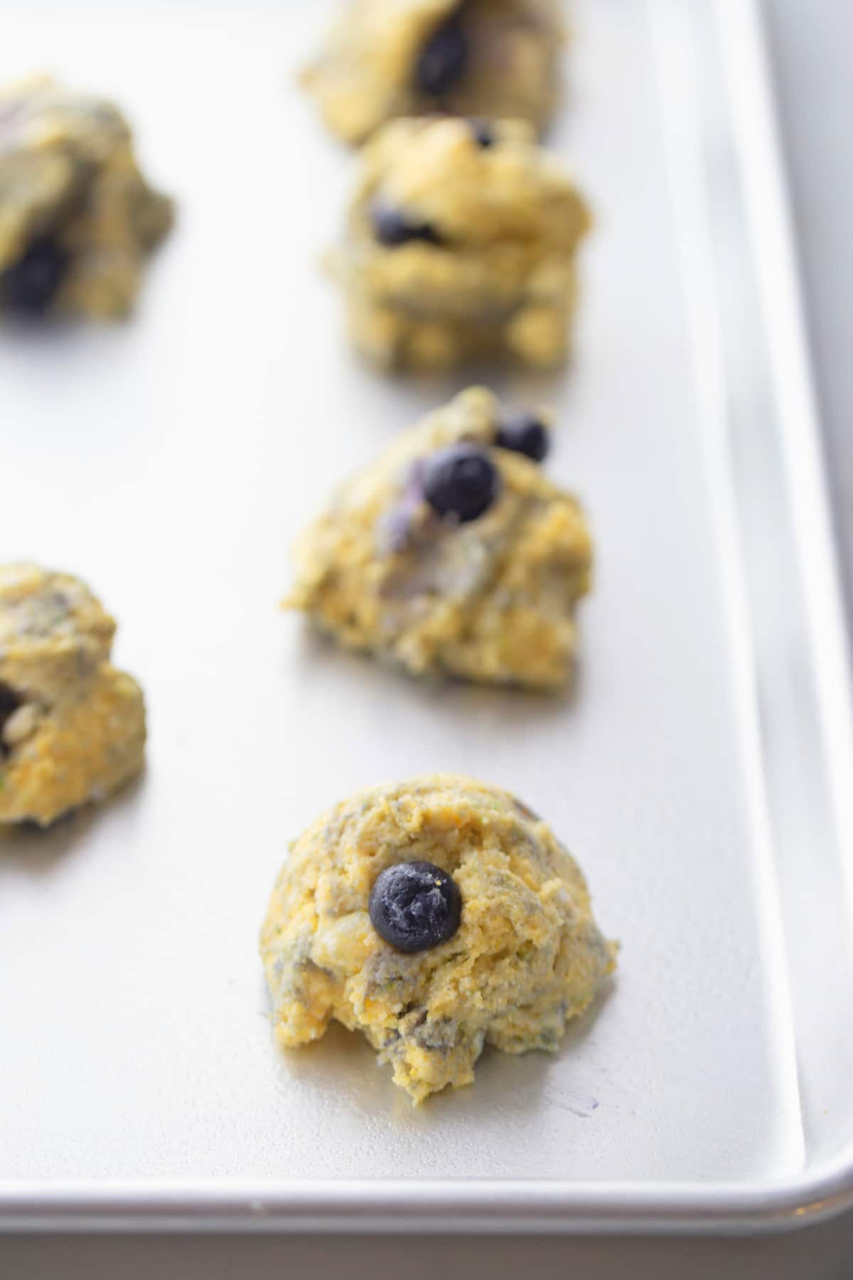 Cornmeal-Blueberry Drop Scones before baking Raw cornmeal-blueberry drop scone dough mounded onto a baking sheet, ready to go into the oven.