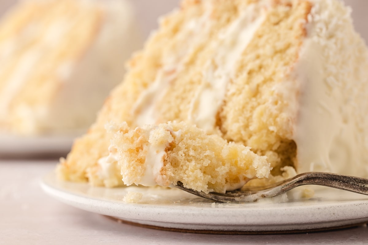 This pineapple coconut cake is a tropical-flavored dream dessert. It's the perfect blend of sweet pineapple and nutty coconut in every bite. a slice of pineapple coconut cake