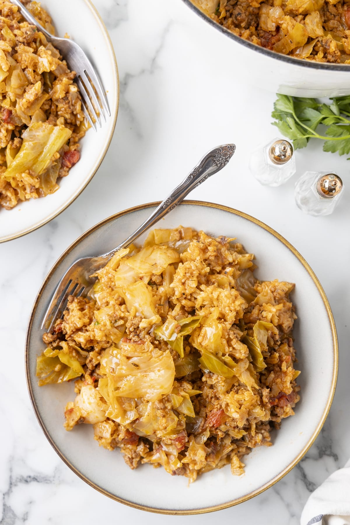 unstuffed cabbage rolls in bowls Overhead view of unstuffed cabbage rolls with beef, rice, and cabbage served in bowls with forks.