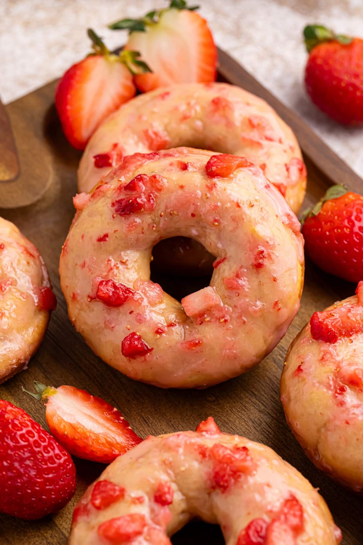 This is the perfect recipe for strawberry glazed baked doughnuts. What could better than fluffy vanilla doughnuts topped with a sweet and tangy, fresh strawberry glaze. These doughnuts are perfect for a weekend breakfast, back-to-school treat, brunch or a holiday morning. baked doughnuts with strawberry glaze