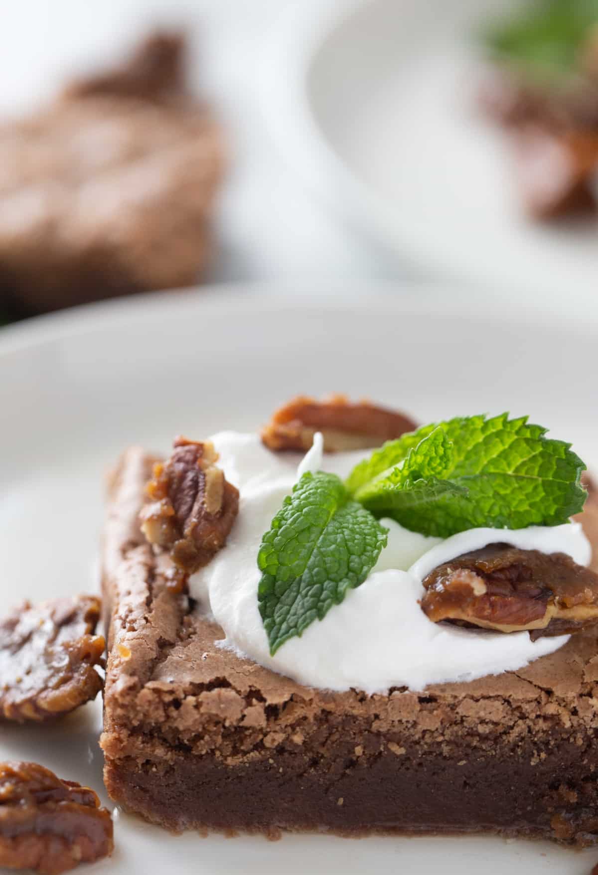 Closeup of a finished Mint Julep Brownie with visible pecans and whipped cream
