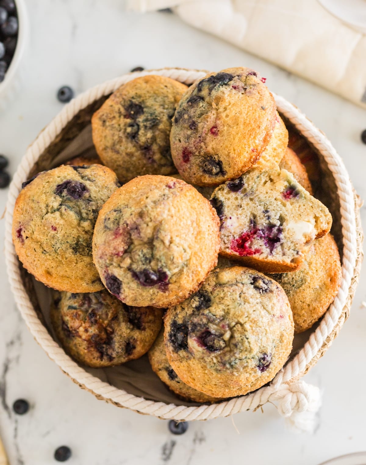 Tender berry muffins that aren't too sweet, with a light and airy texture and chunks of cream cheese baked into every bite. basket of berry muffins