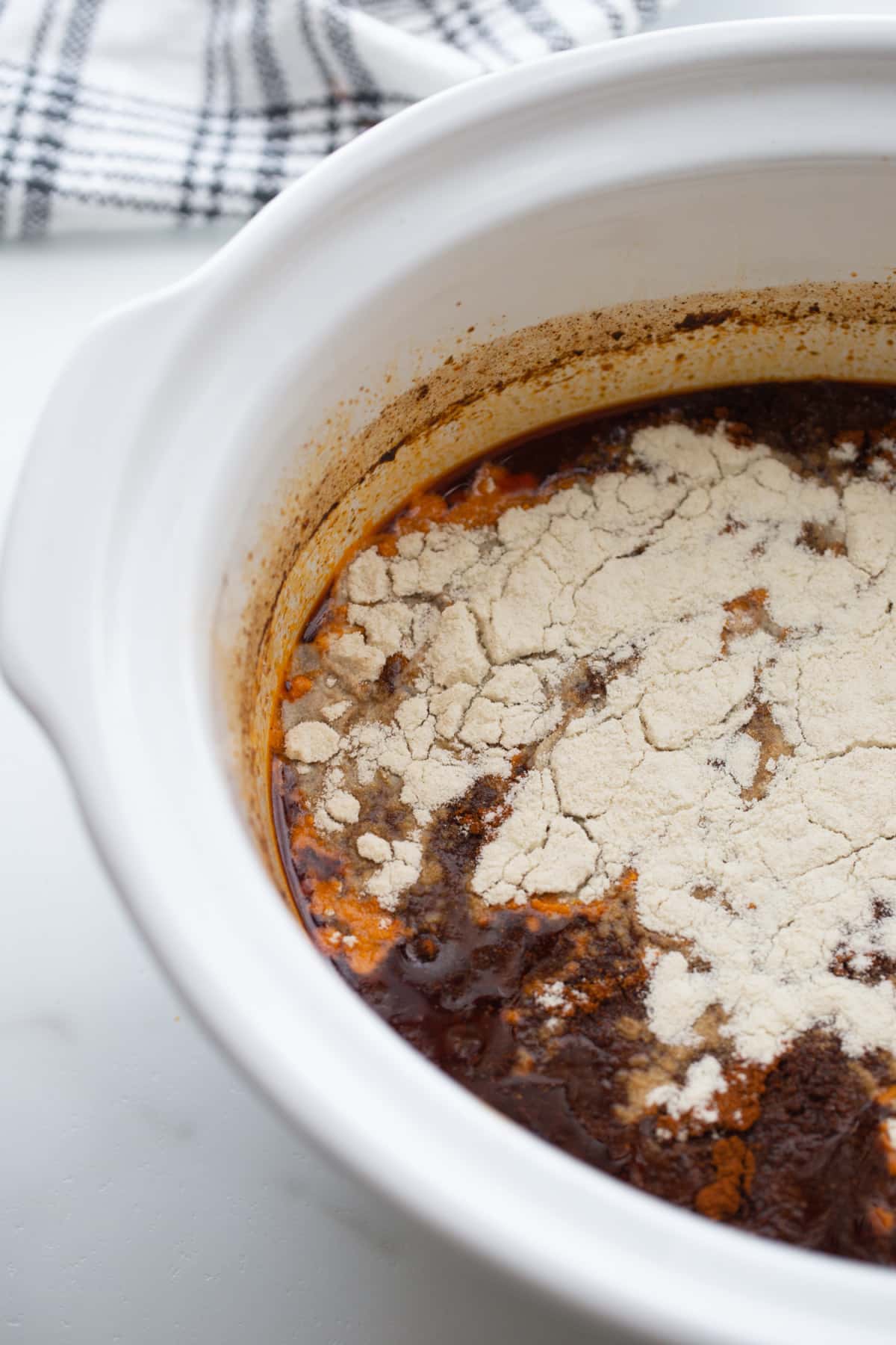 masa harina added to the slow cooker full of las palmas red chile sauce
