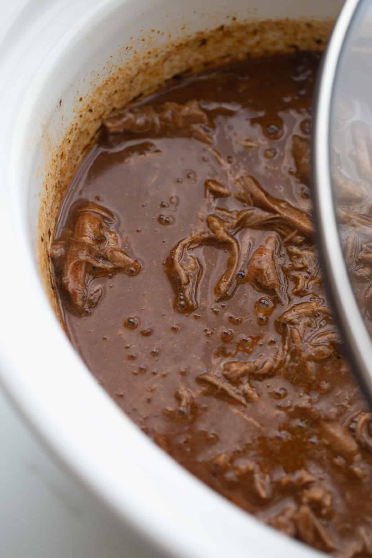 showing thicker red chile sauce in the slow cooker
