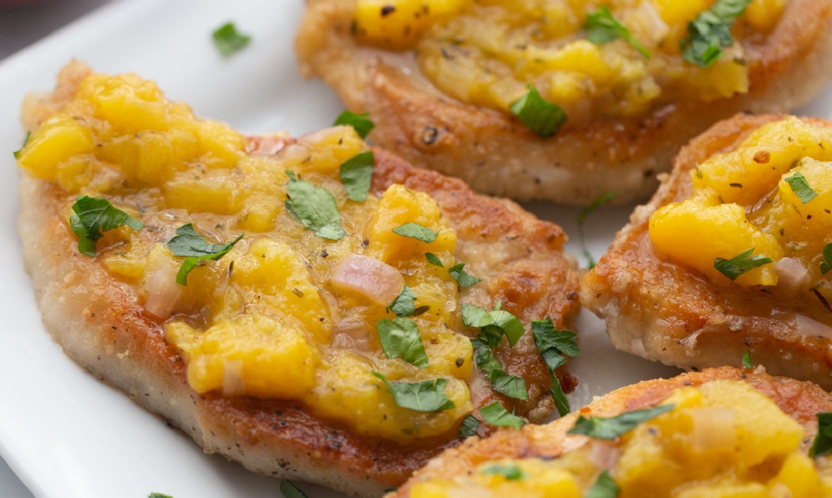 Closeup of pork chops with peach chutney Closeup of juicy pork chops topped with homemade peach chutney