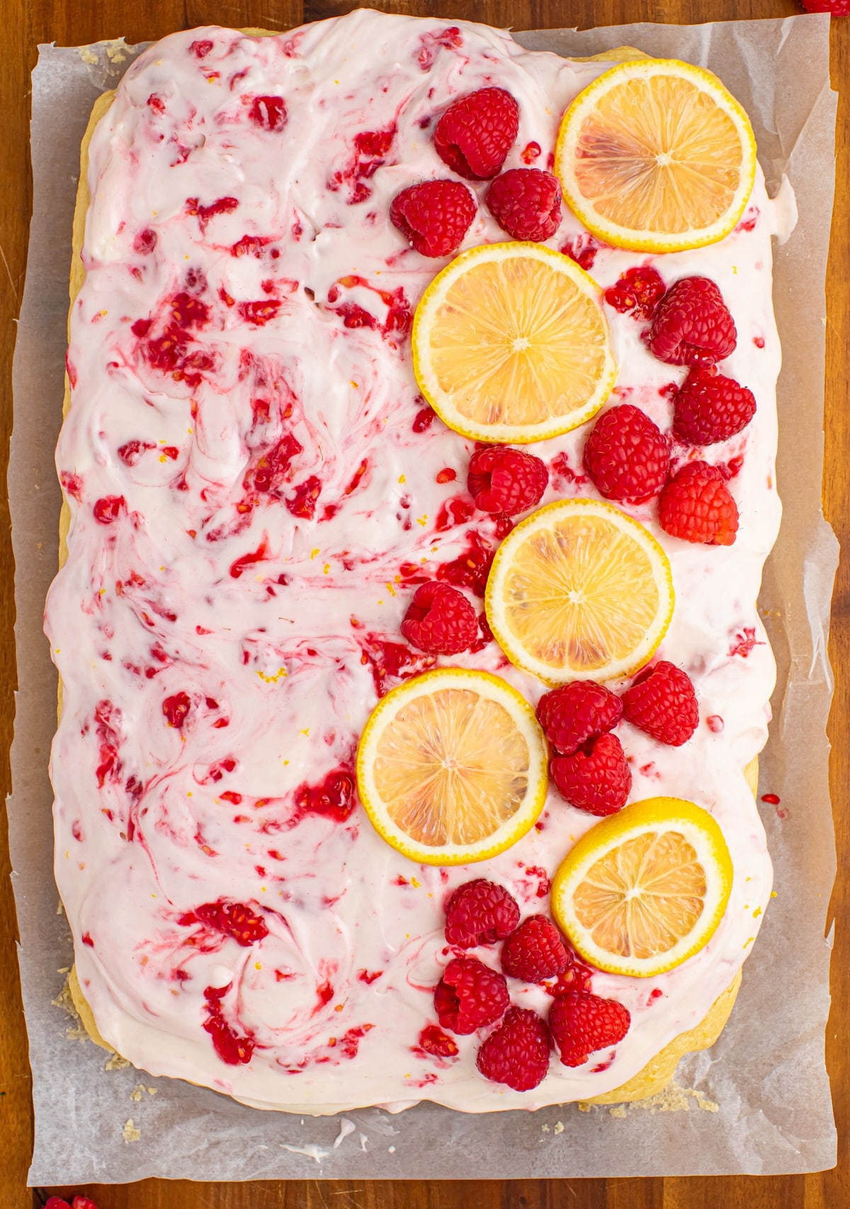 A buttermilk lemon raspberry frosted sheet cake made with —sun-ripened raspberries and tart lemon. It's one deliciously tender cake! Sheet cake frosted