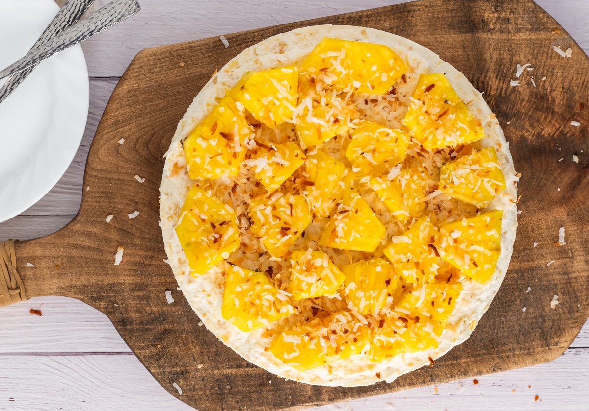 You'll love the tropical flavors of this pineapple delight cheesecake, featuring a golden Oreo crust, rich cream cheese layer, and fluffy pineapple mousse, topped with fresh pineapple and coconut. It's perfect for any gathering, from barbecues to potlucks. pineapple delight