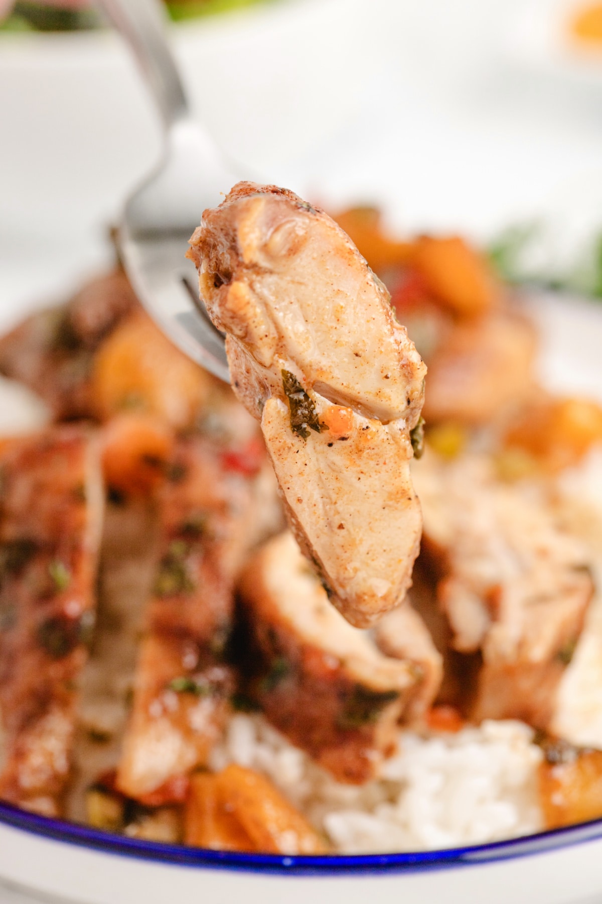 apricot chicken thigh on fork close-up Close-up of a juicy apricot-marinated chicken thigh on a fork, showing the texture.