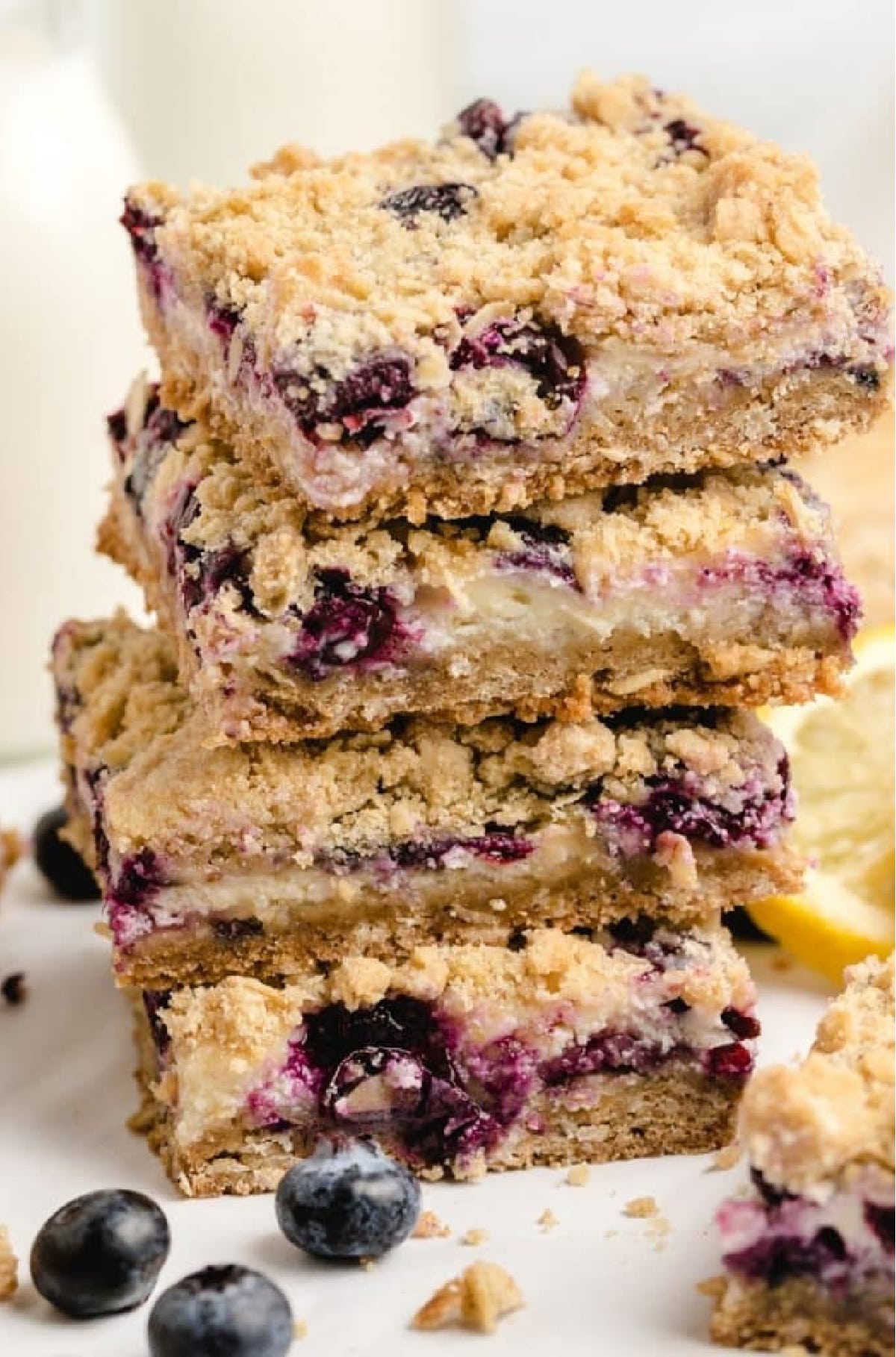 Stack of lemon blueberry crumble bars showing layers of filling and crumble