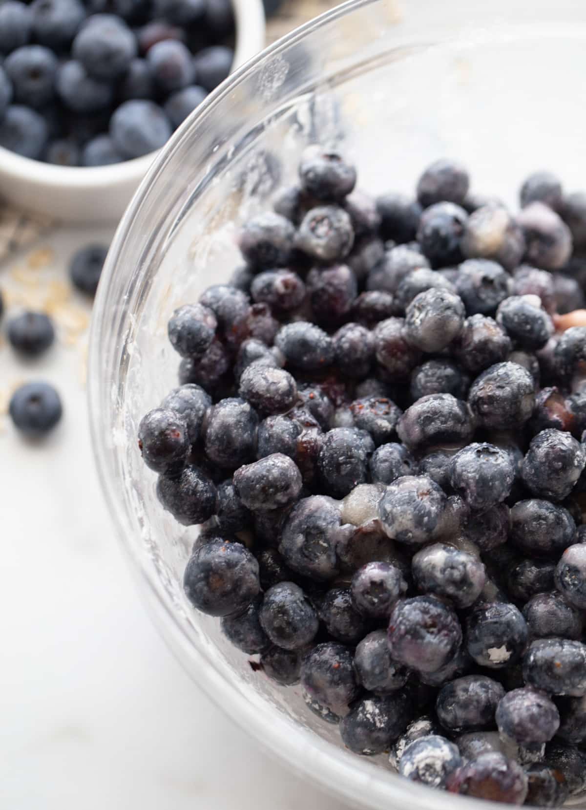 blueberry filling with lemon, sugar, and cornstarch Blueberries mixed with filling ingredients in clear bowl