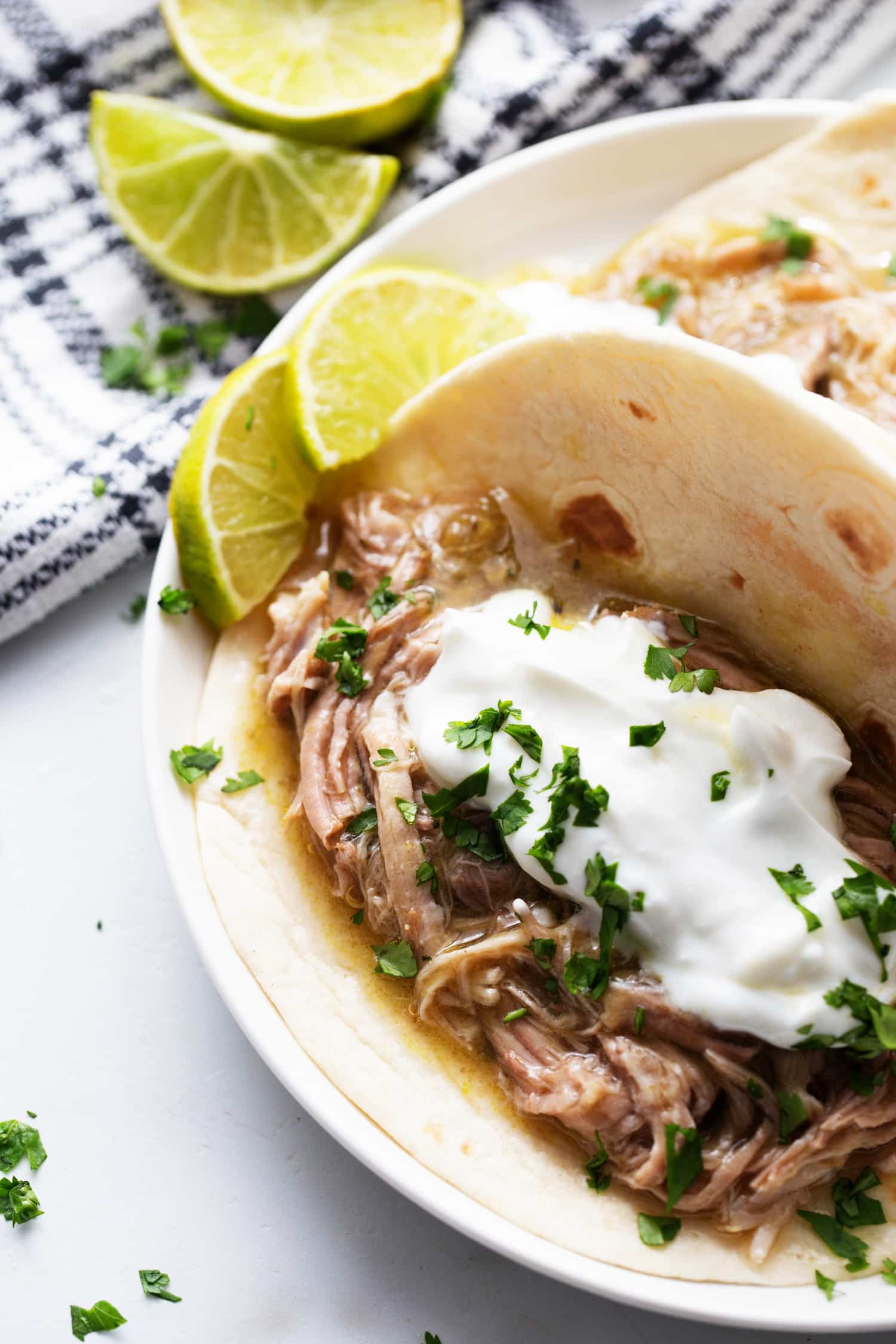 Pulled pork chile verde in a soft tortilla with sour cream and cilantro
