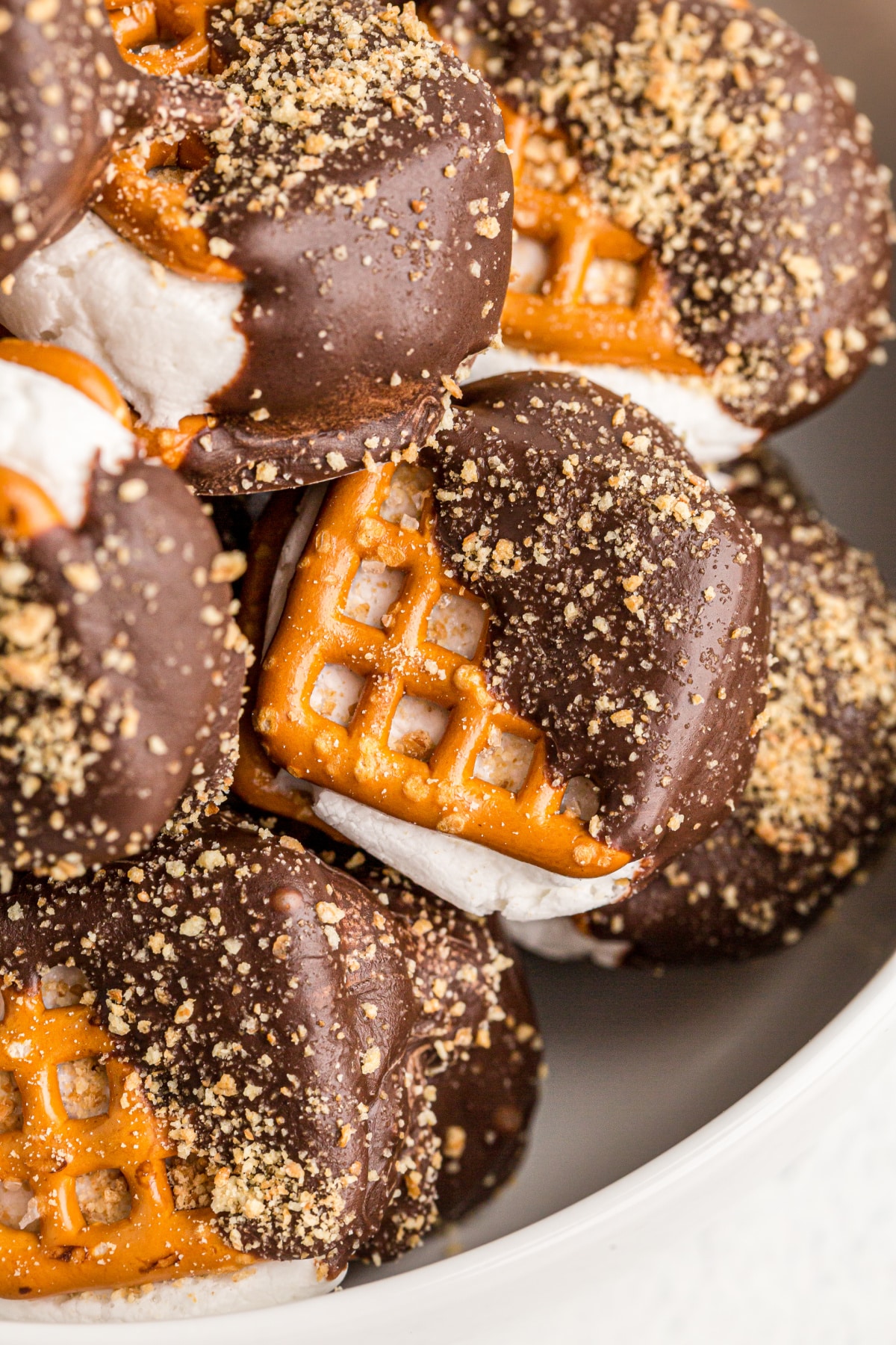 Close-up view of chocolate-dipped s’mores pretzels with golden graham crumbs