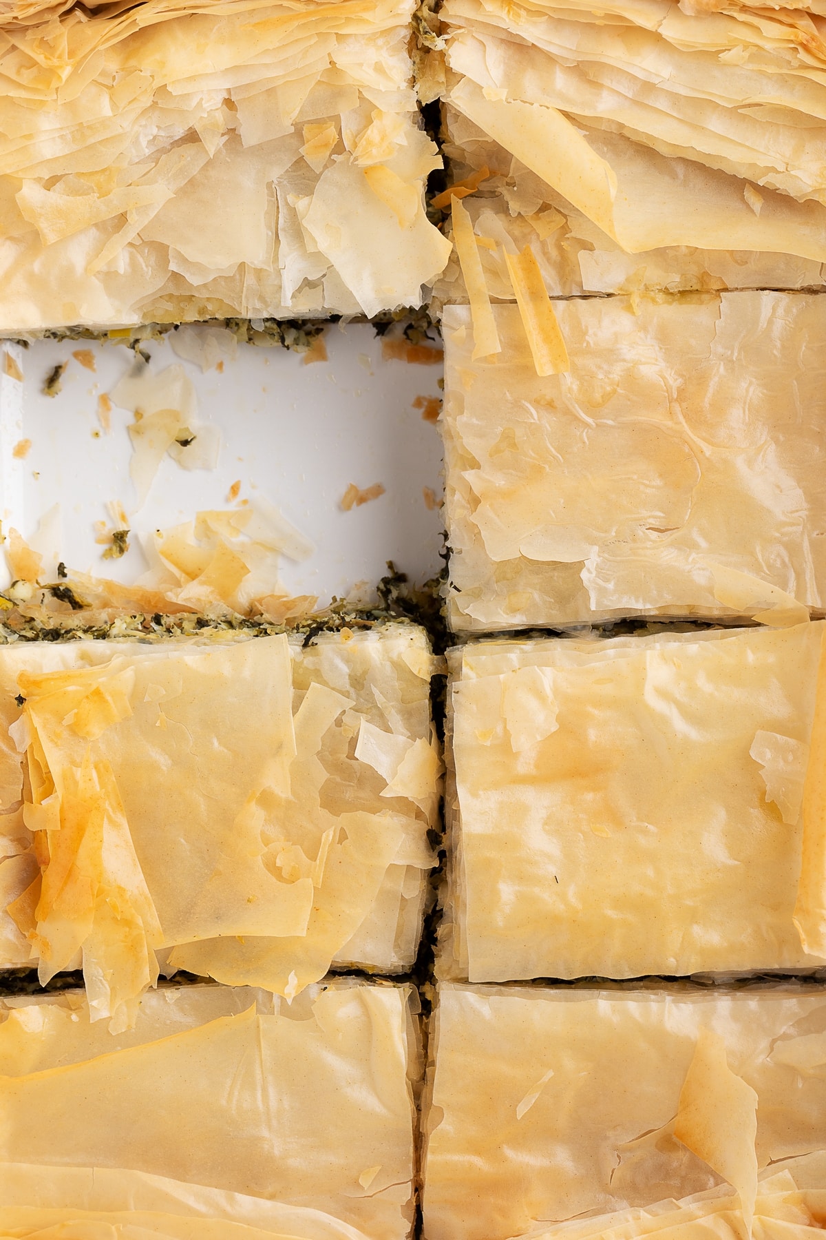 This savory Spanakopita “pie” features a bit of a twist on the traditional filling. Layers of flaky phyllo dough with a rich filling of spinach, artichoke hearts, and sautéed leeks. Greek spinach pie