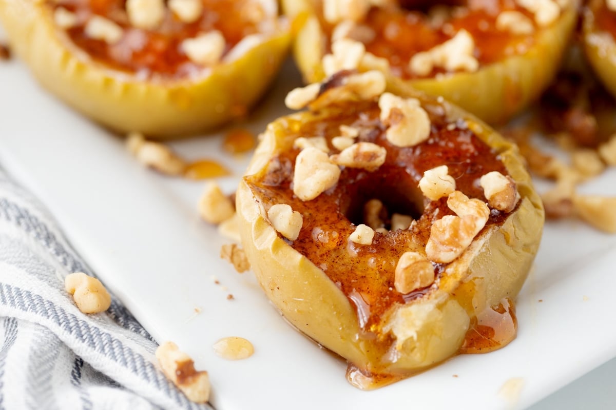 Tender baked apple halves topped with warm maple-walnut sauce and toasted walnuts. Baked apples with maple syrup, cinnamon and toasted walnuts