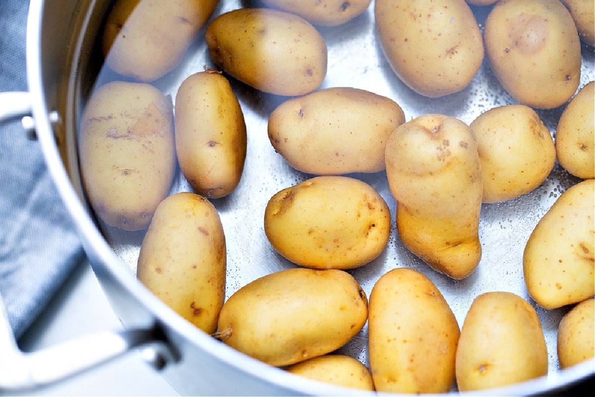 Small potatoes in a pot of water before boiling, the first step for making salt and vinegar smashed potatoes.