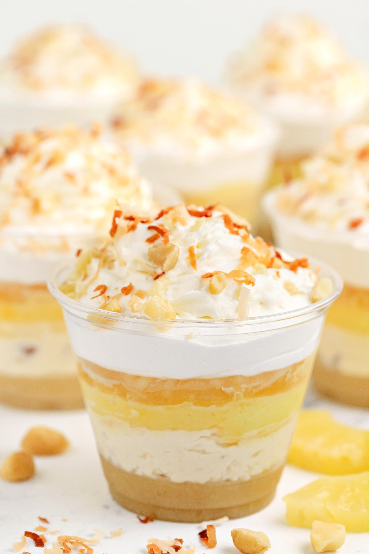 Hawaiian Dream Dessert Cups with pineapple, coconut, and macadamia layers Hawaiian Dream Dessert Cups layered with macadamia nut crust, coconut cream pudding, pineapple, and whipped topping, finished with toasted coconut and chopped macadamias by Noble Pig.
