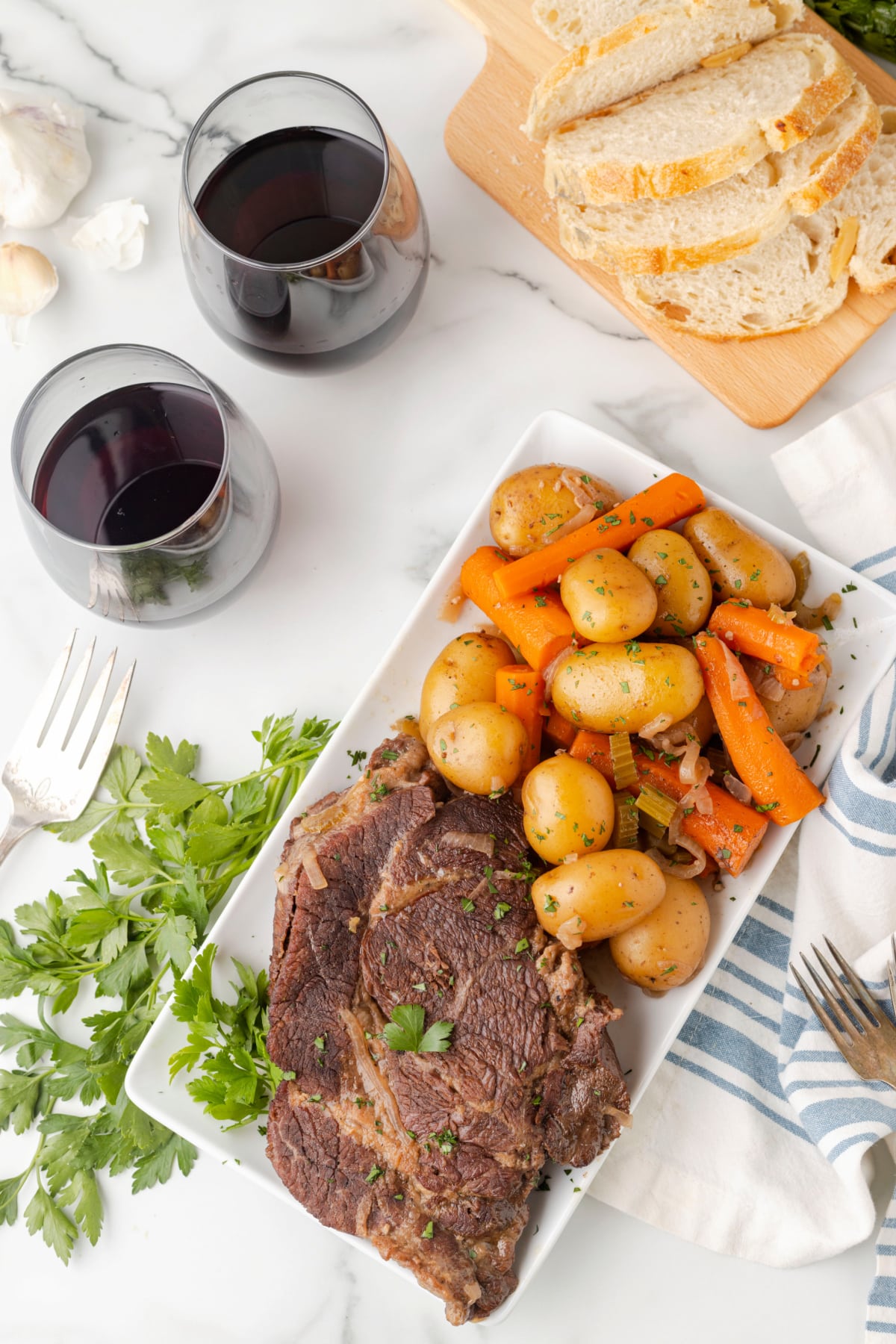 Classic pot roast sliced on serving platter with vegetables Sliced pot roast served on a platter with carrots and potatoes, ready to serve