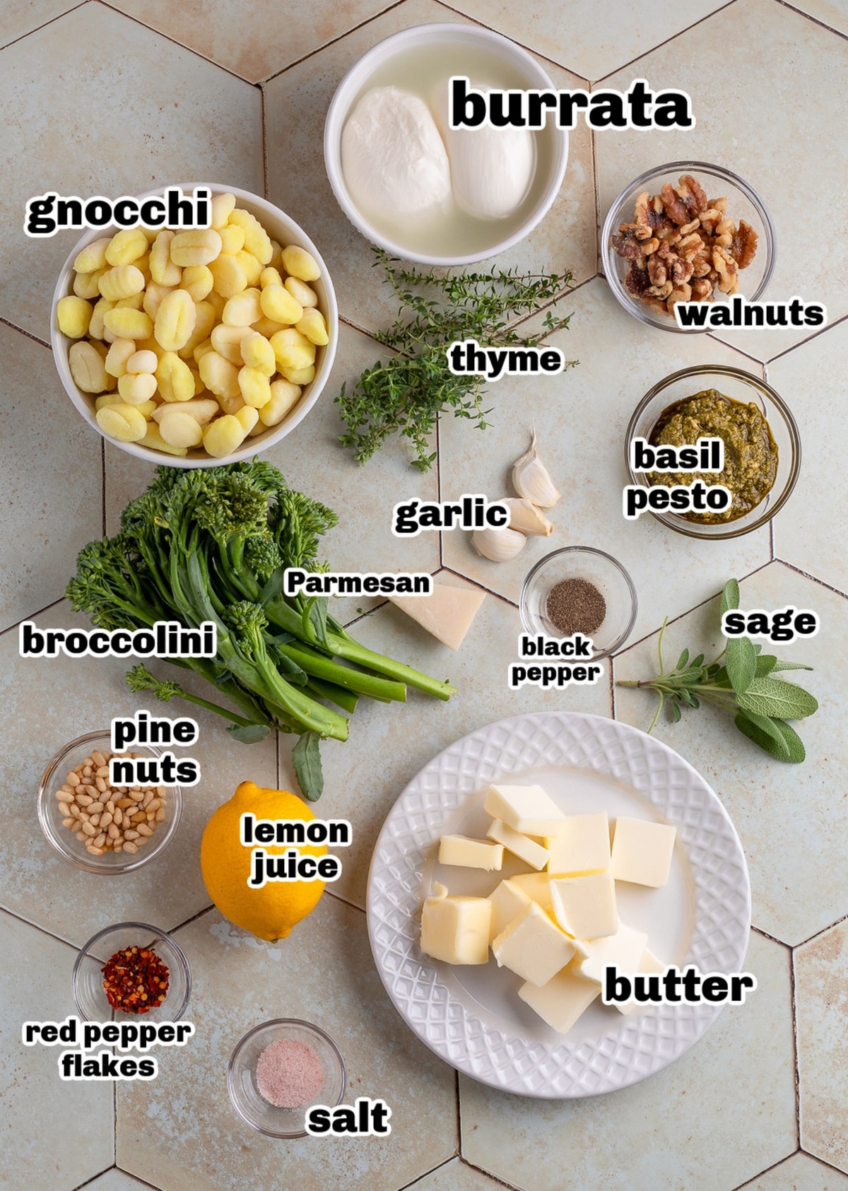 Overhead view of ingredients for gnocchi with burrata, pesto, and brown butter, including broccolini, walnuts, pine nuts, lemon, and fresh herbs.