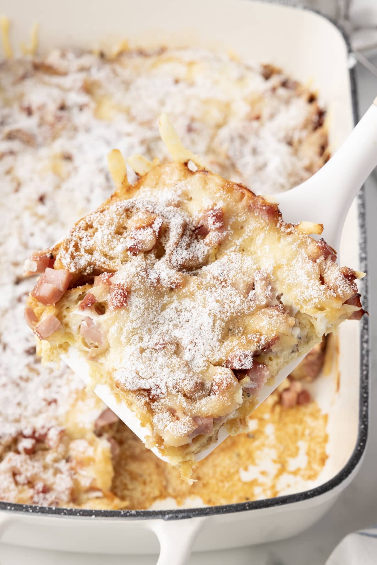 Overhead view of a spatula serving a portion of Monte Cristo Casserole.