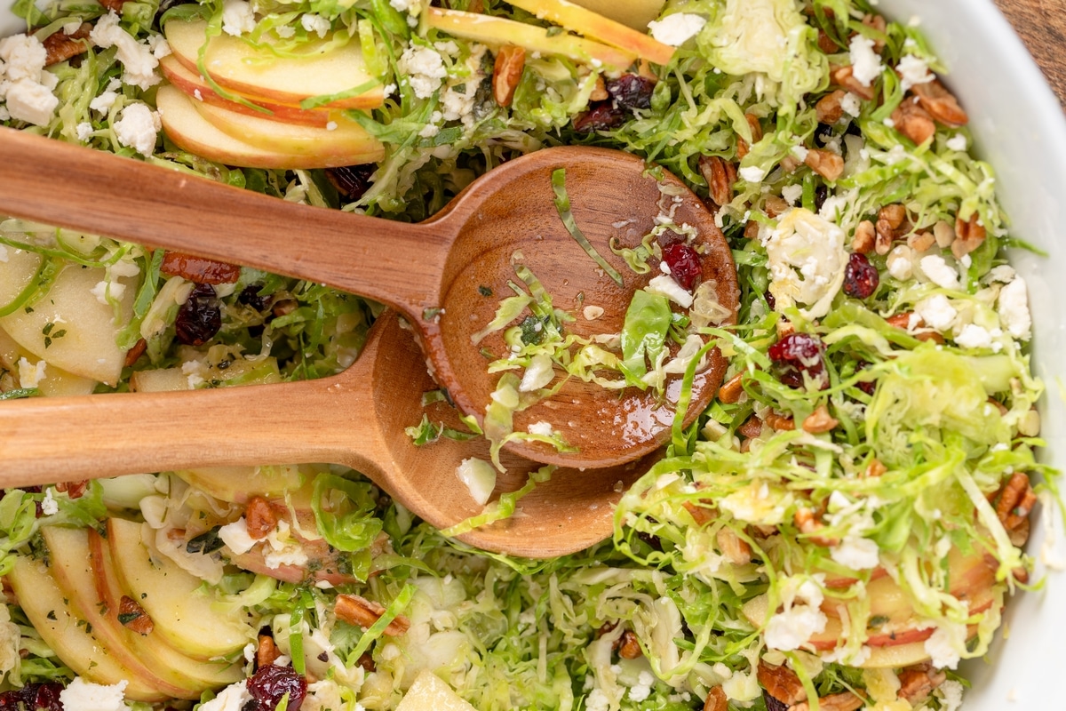 Shaved Brussels Sprouts Salad with serving spoons ready Brussels Sprouts Salad with wooden serving spoons