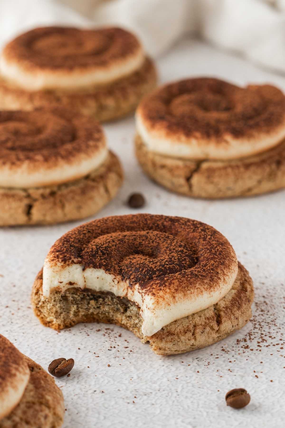 Bite revealing the espresso-flavored cookie center. A close-up of a cookie with creamy frosting and a bite taken, showing the soft, espresso-infused center.