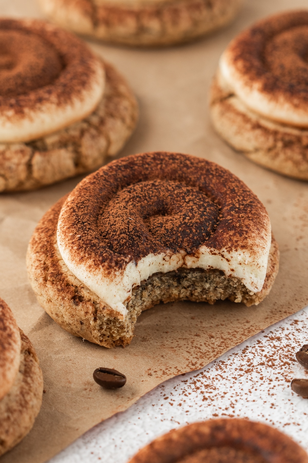 Tiramisu cookie revealing a bite. Half-eaten cookie resting on a plate, showcasing its soft texture and rich espresso flavor.