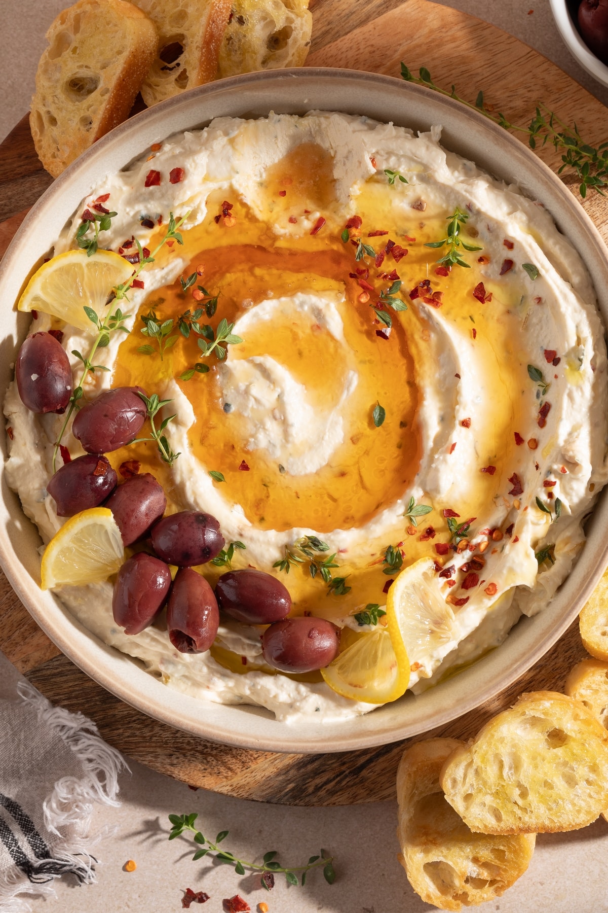 Overhead view of whipped feta roasted garlic dip with honey and baguette.