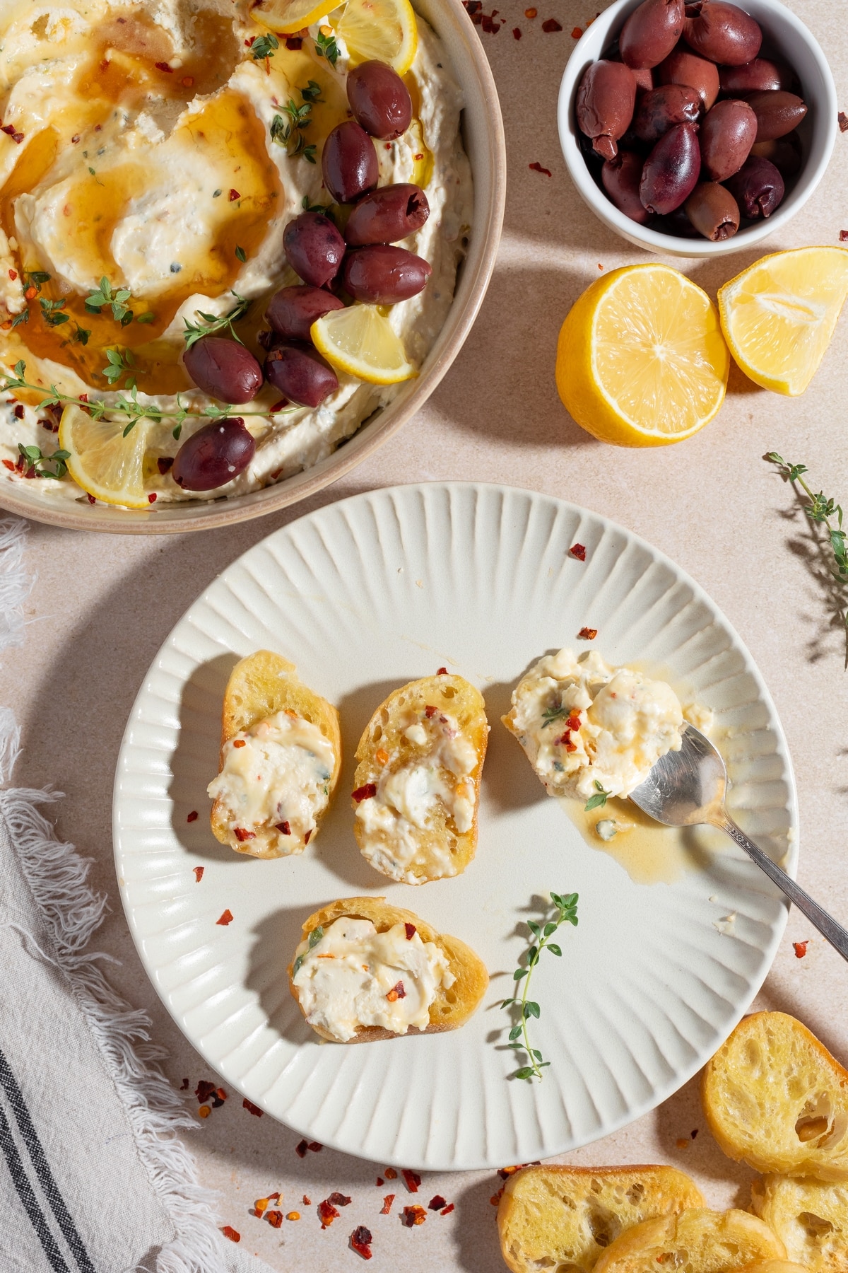 Whipped feta roasted garlic dip with honey served with baguette slices topped with the dip.