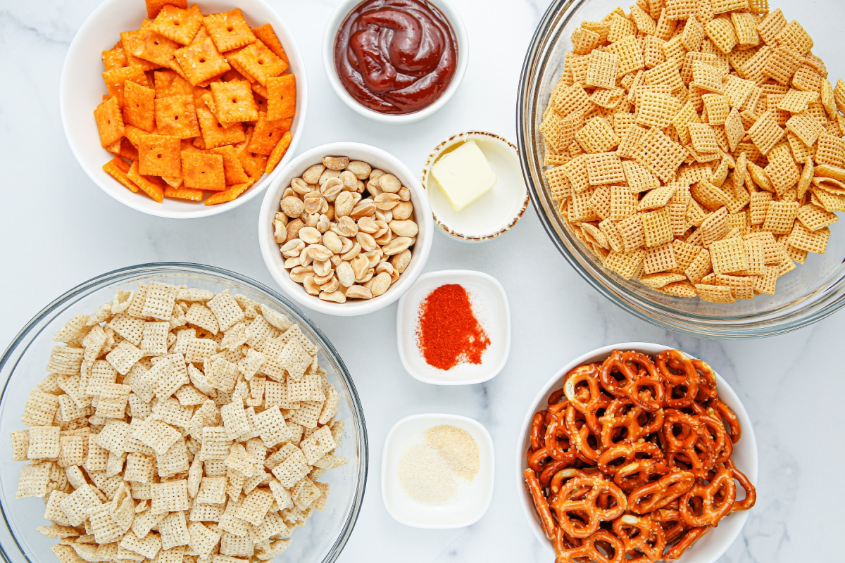 Ingredients for BBQ Chex snack mix including Rice Chex, Corn Chex, pretzels, Cheez-Its, peanuts and BBQ sauce