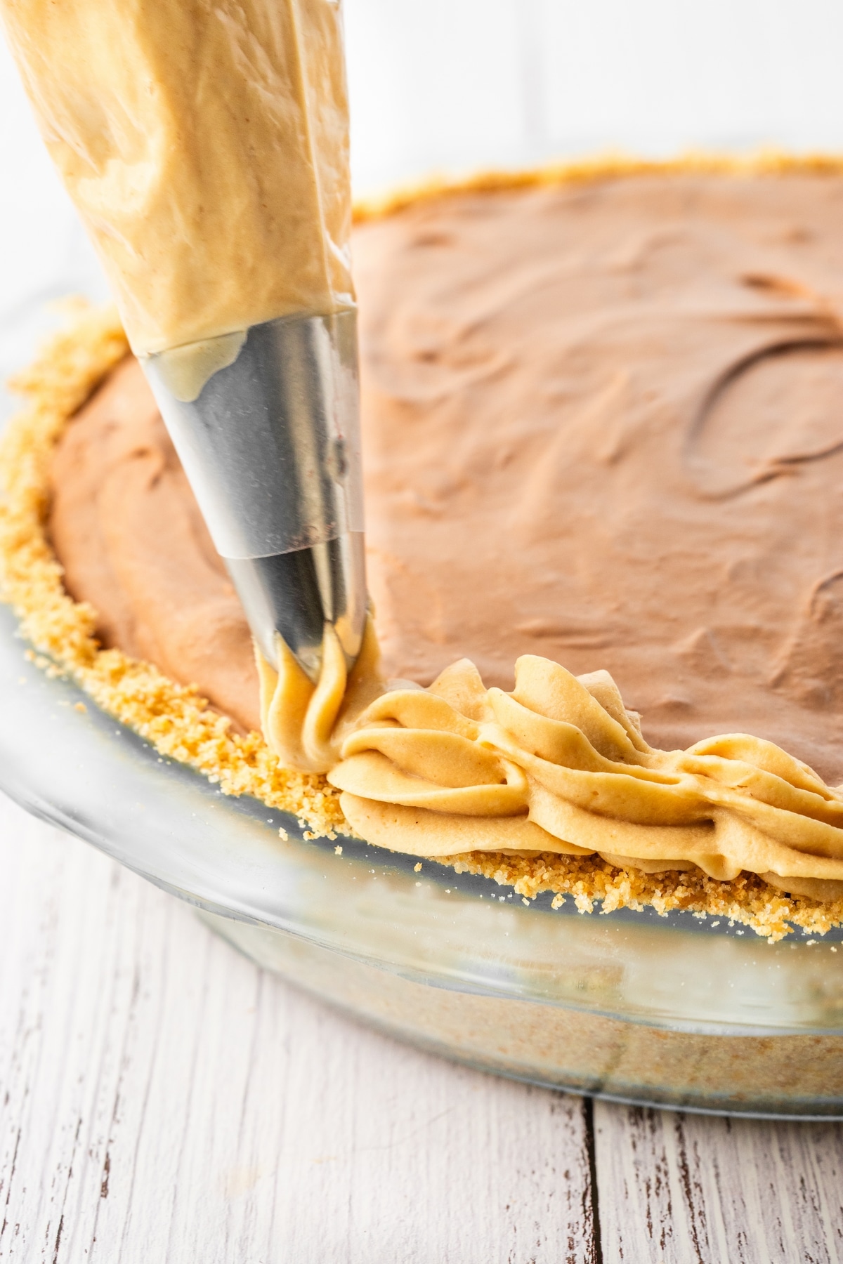 piping edging on peanut butter chocolate cream pie
