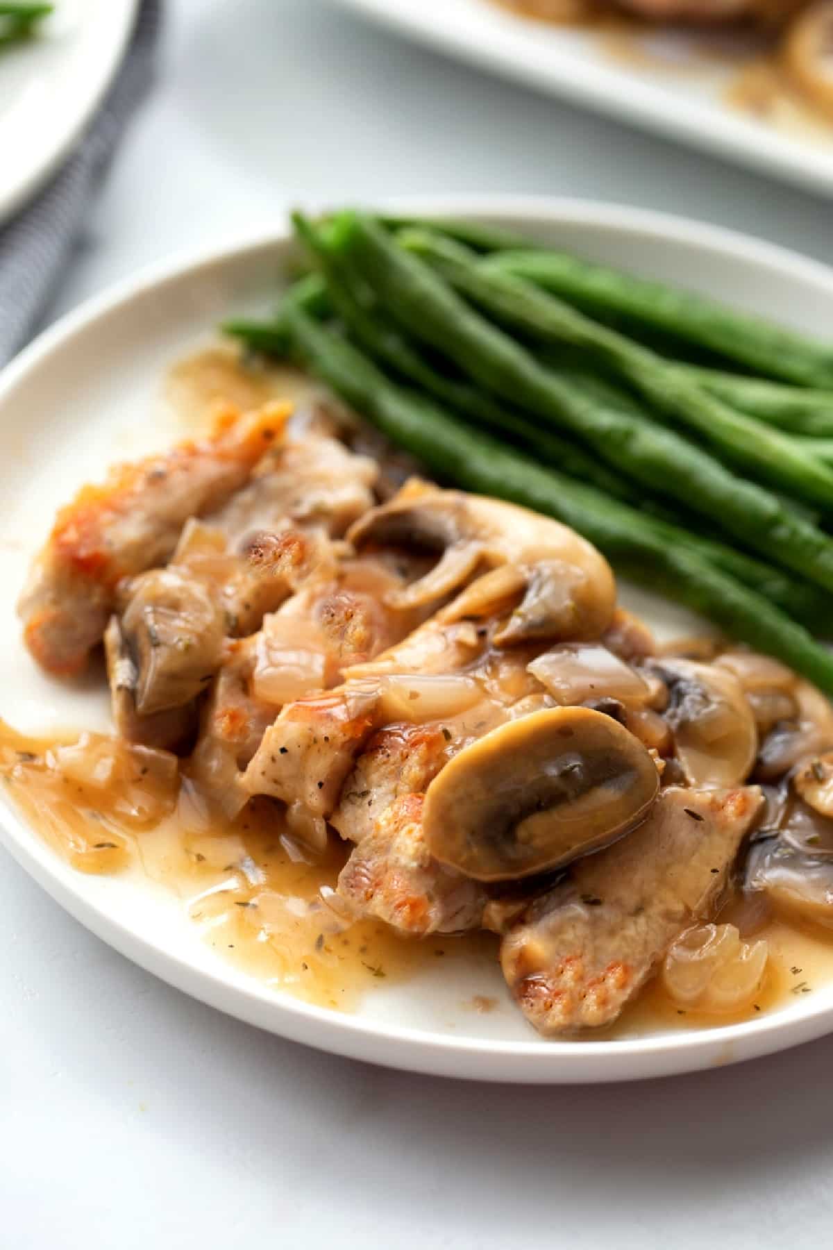 Pork Marsala served with green beans and mushroom Marsala sauce.