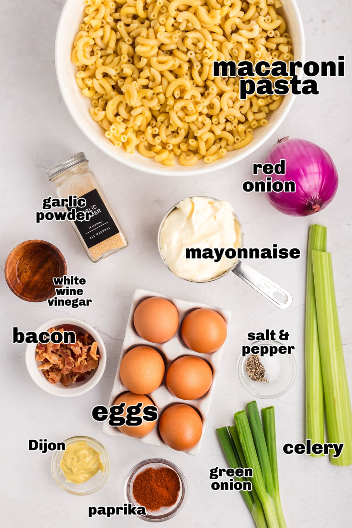 Deviled Egg Pasta Salad ingredients A flat lay of all the ingredients for deviled egg pasta salad, including eggs, pasta, mayo, mustard, bacon, and seasonings.