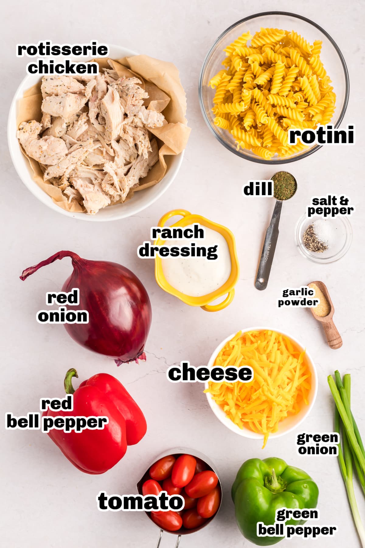 Chicken Ranch Pasta Salad ingredients All ingredients for chicken ranch pasta salad laid out on a white surface, including pasta, veggies, chicken, and dressing.