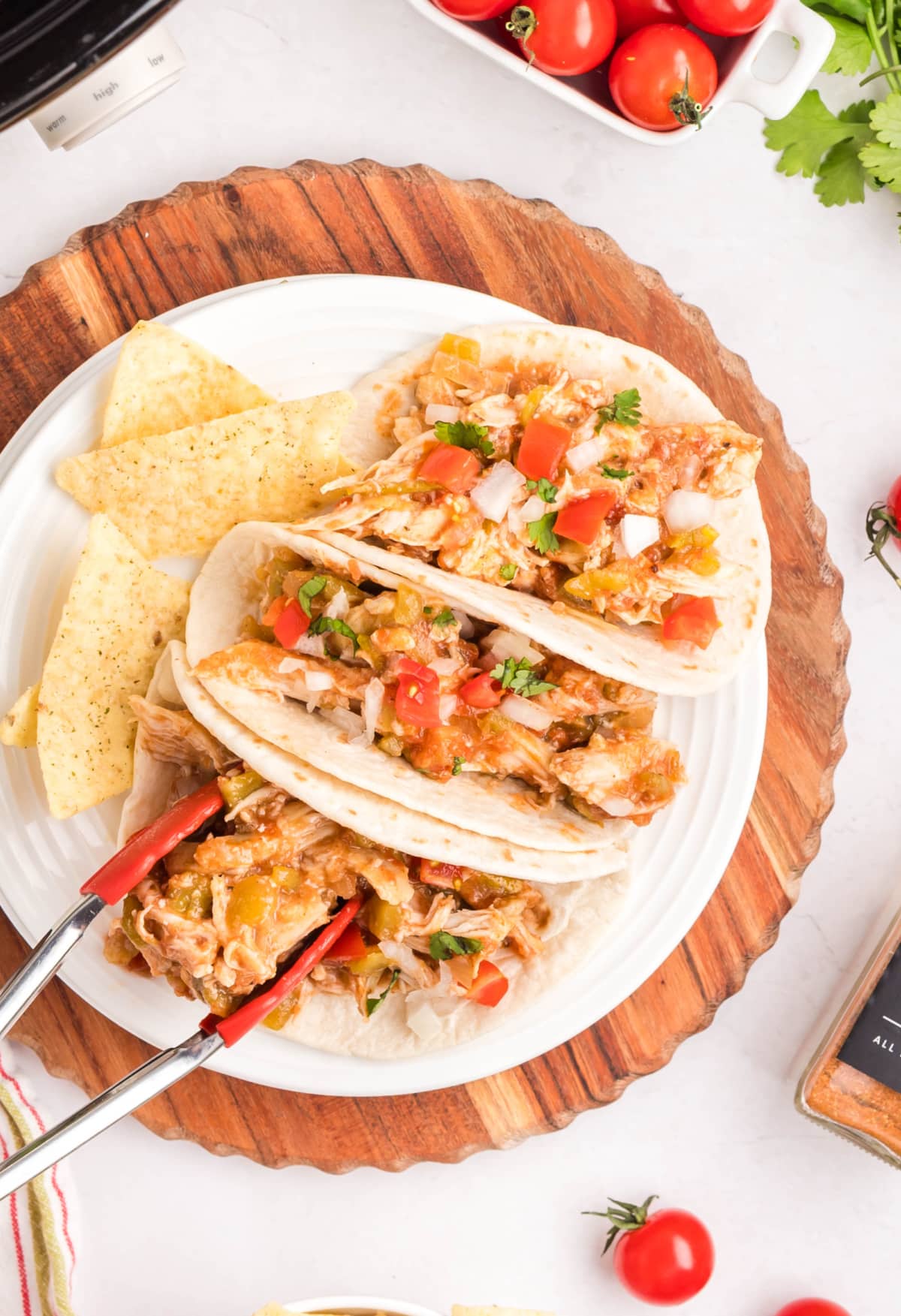 Side view of assembled shredded chicken tacos on a plate, ready to serve.