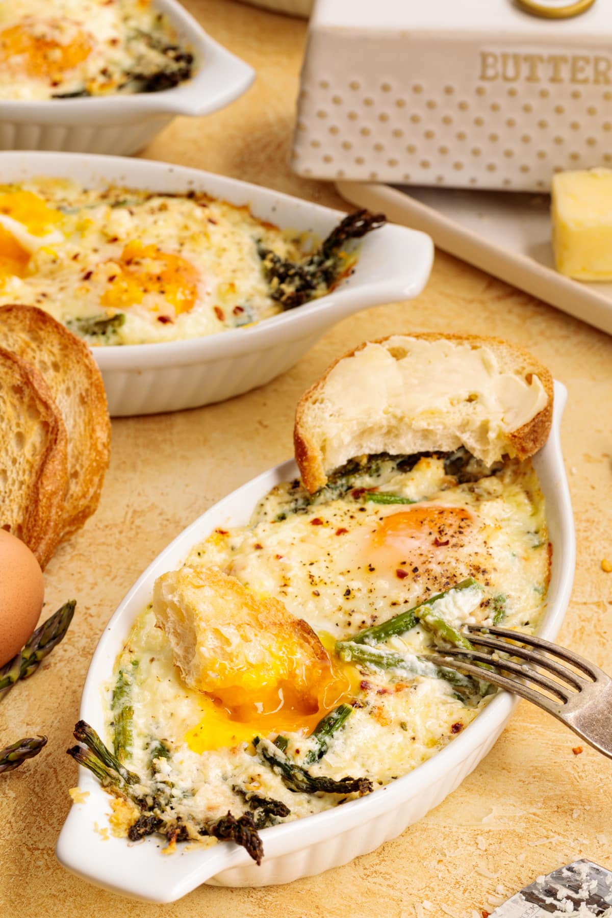 Overhead image of a fork resting next to the ramekin of baked eggs. 