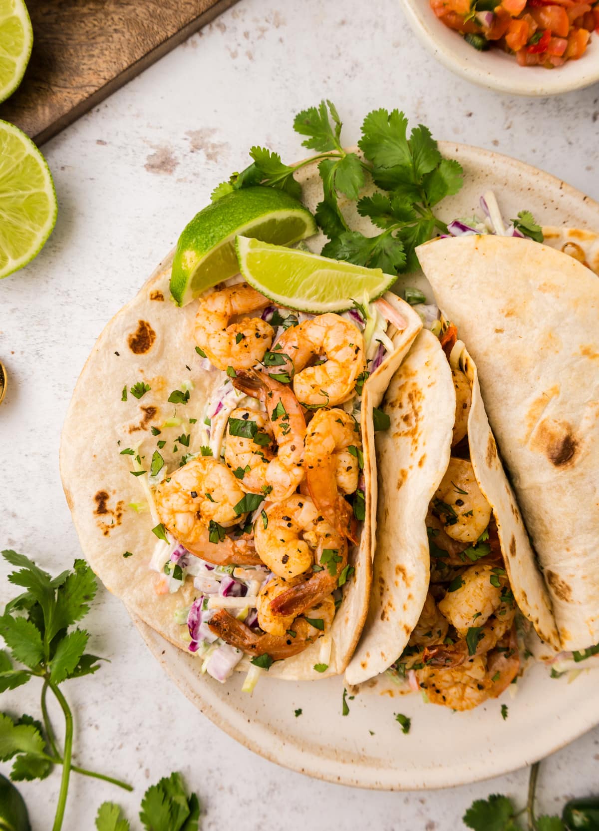 Cajun Shrimp Tacos on a plate Top view of one open-faced taco showing the filling and one closed taco ready to serve