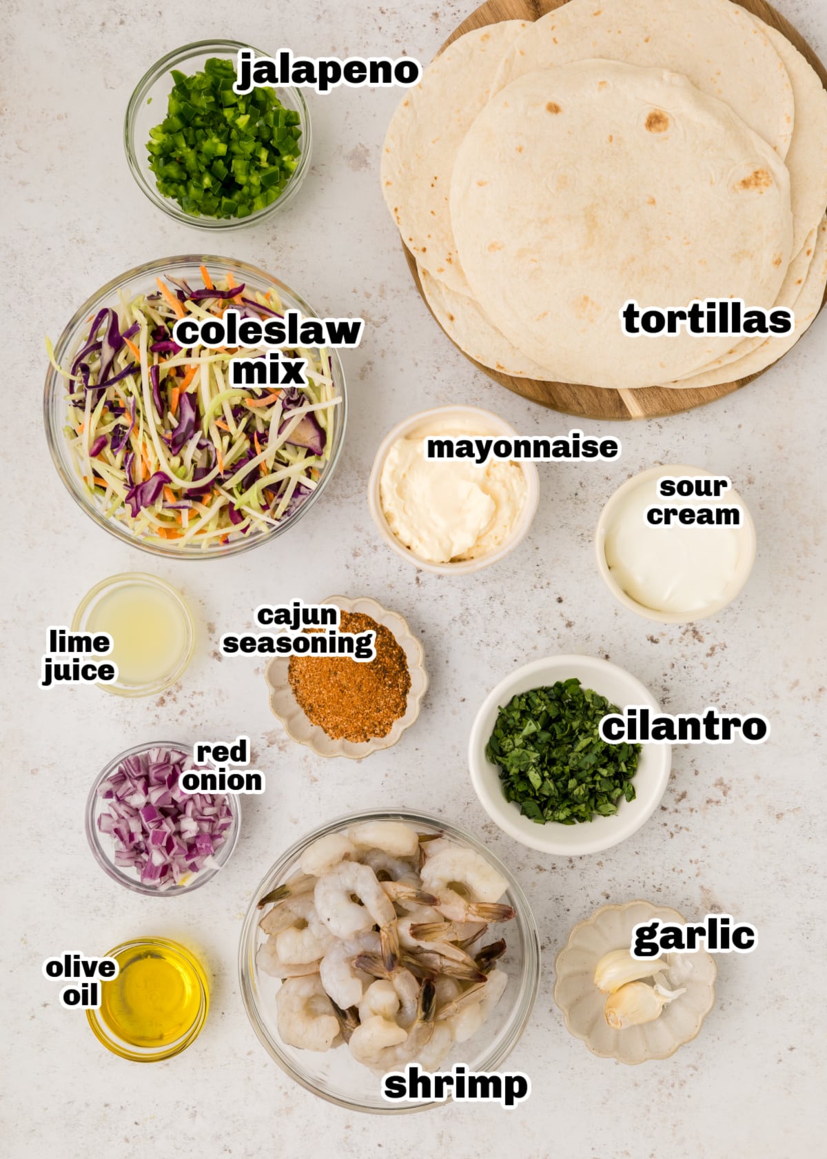 Cajun Shrimp Tacos ingredients Ingredients laid out for cajun shrimp tacos, including shrimp, slaw mix, spices, and tortillas