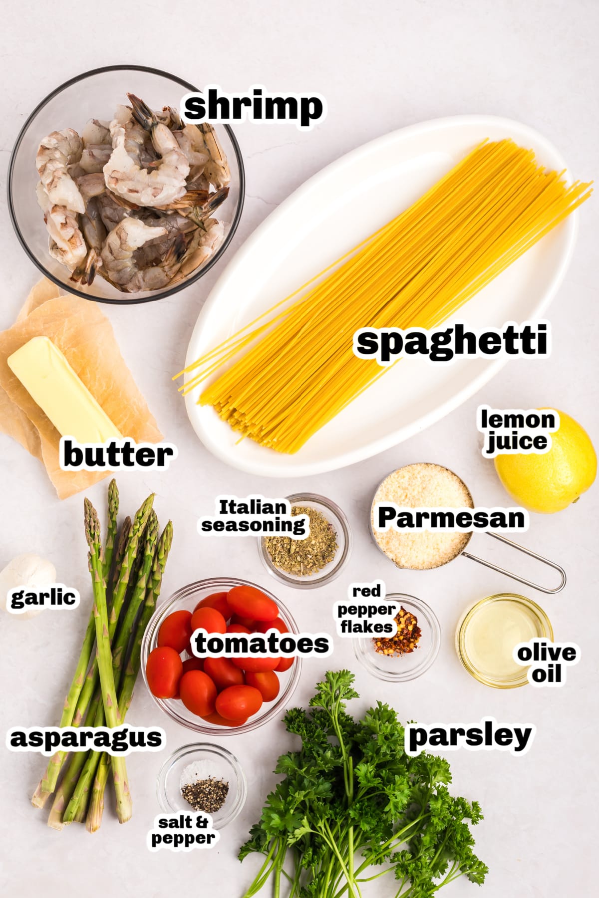 Garlic Shrimp Pasta with Asparagus and Tomatoes ingredients All ingredients for garlic shrimp pasta arranged on a counter, including shrimp, pasta, garlic, asparagus, tomatoes, and seasonings.