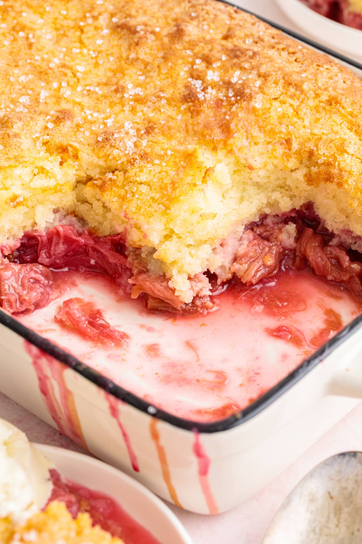 Side angle of the cobbler in the baking dish, showing the tender cake topping and fruit filling underneath.