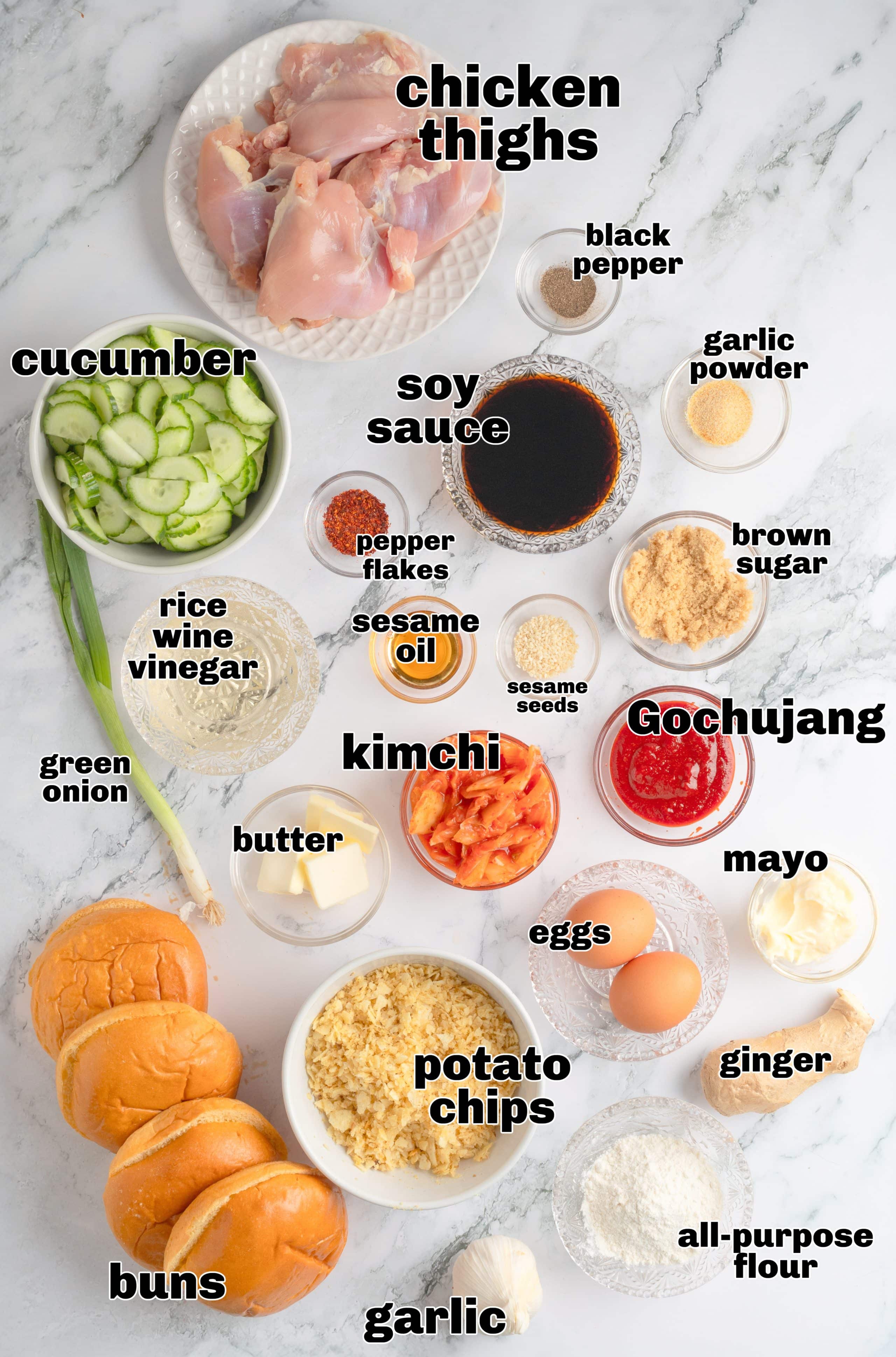 Ingredients laid out for Gochujang Chicken Sandwich with potato chip crust Overhead shot of ingredients for Gochujang Chicken Sandwich including chicken thighs, potato chips, kimchi, and Gochujang