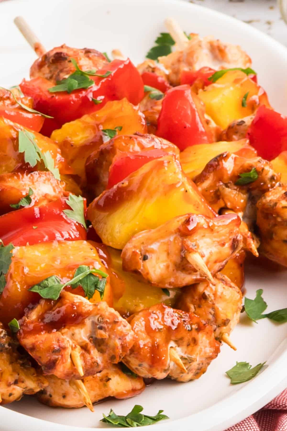  Close-up of baked chicken skewers with BBQ sauce, pineapple, and red pepper