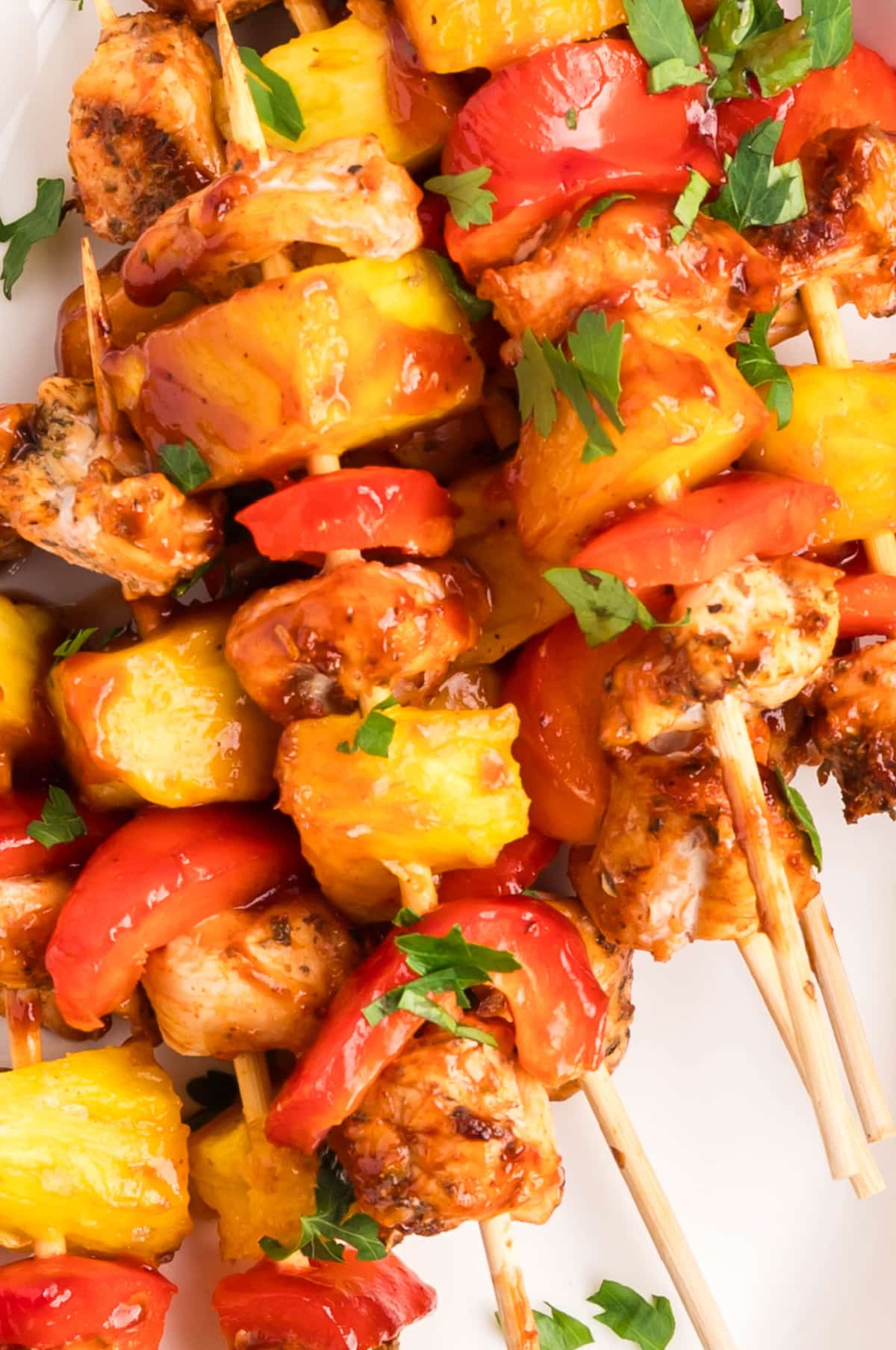Close-up of baked BBQ chicken skewers with sticky sauce and caramelized edges 