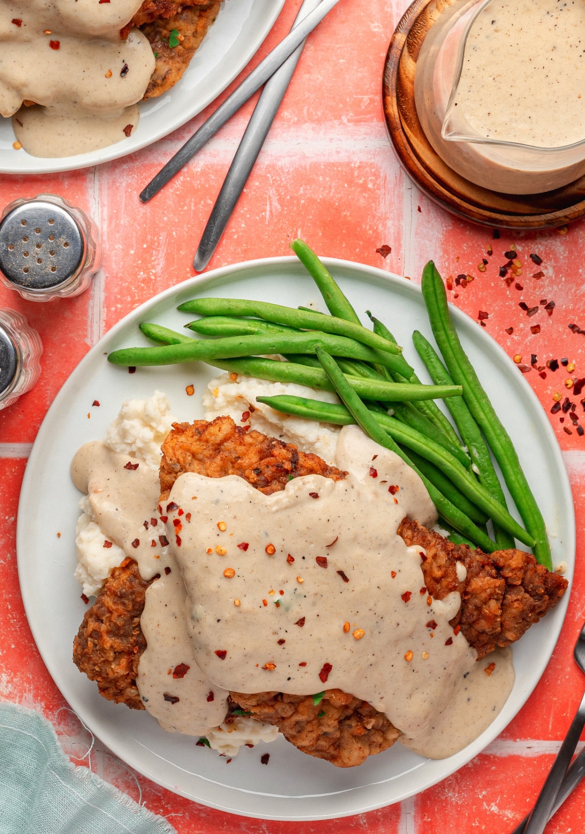 Overhead view of chicken fried steak on a plate smothered in white gravy