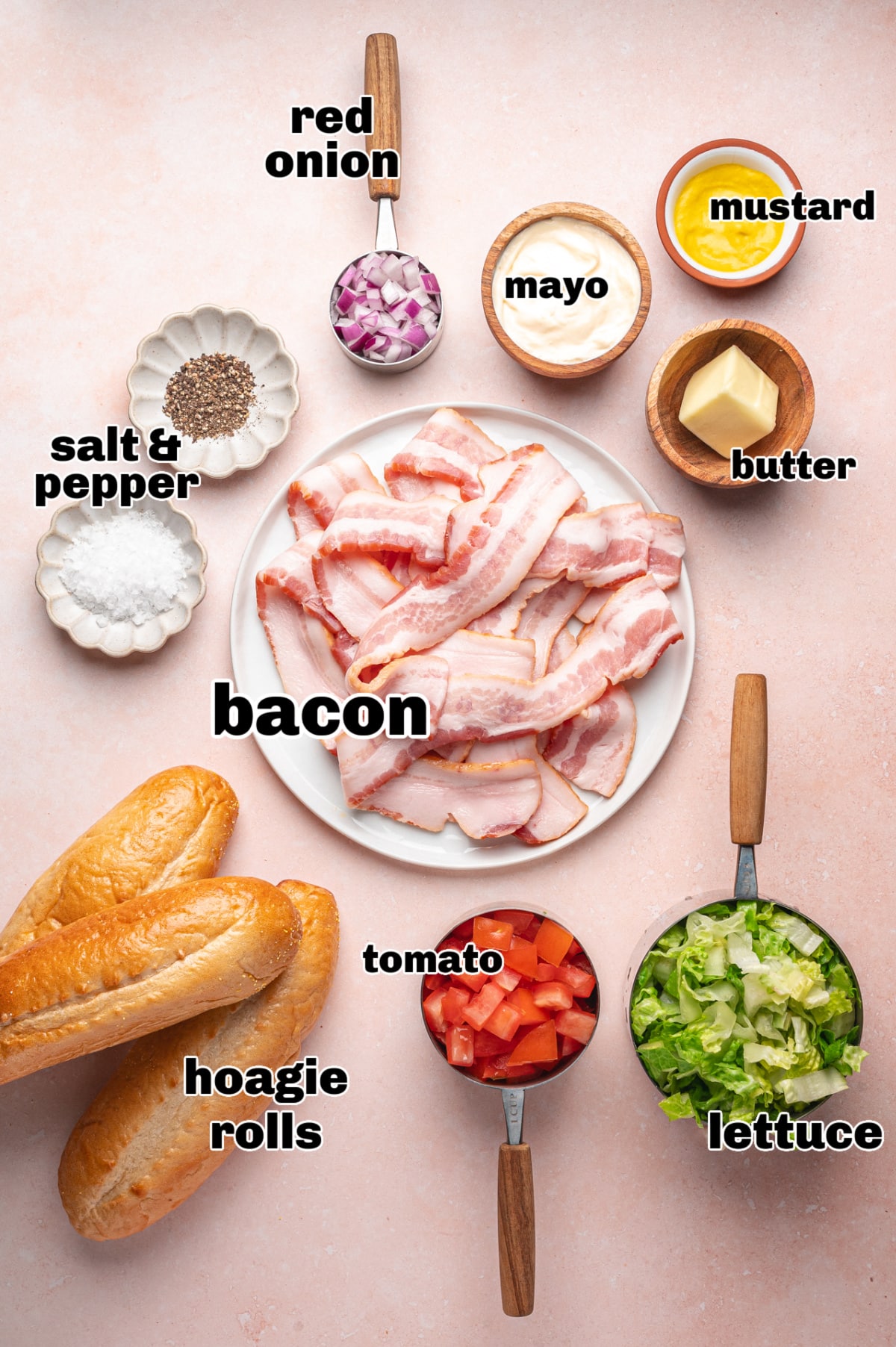 Ingredients for chopped BLT hoagie including bacon, lettuce, tomato, red onion, mayonnaise, mustard, and hoagie rolls