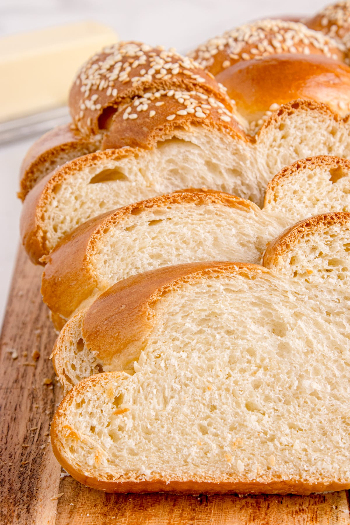 Shiny round sesame challah loaf ready to slice and serve Sliced round challah loaf showing its soft, fluffy crumb and golden crust