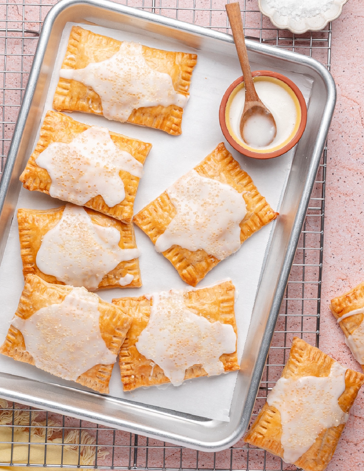 Lemon pop tarts with glaze on a parchment-lined tray, ready to serve 