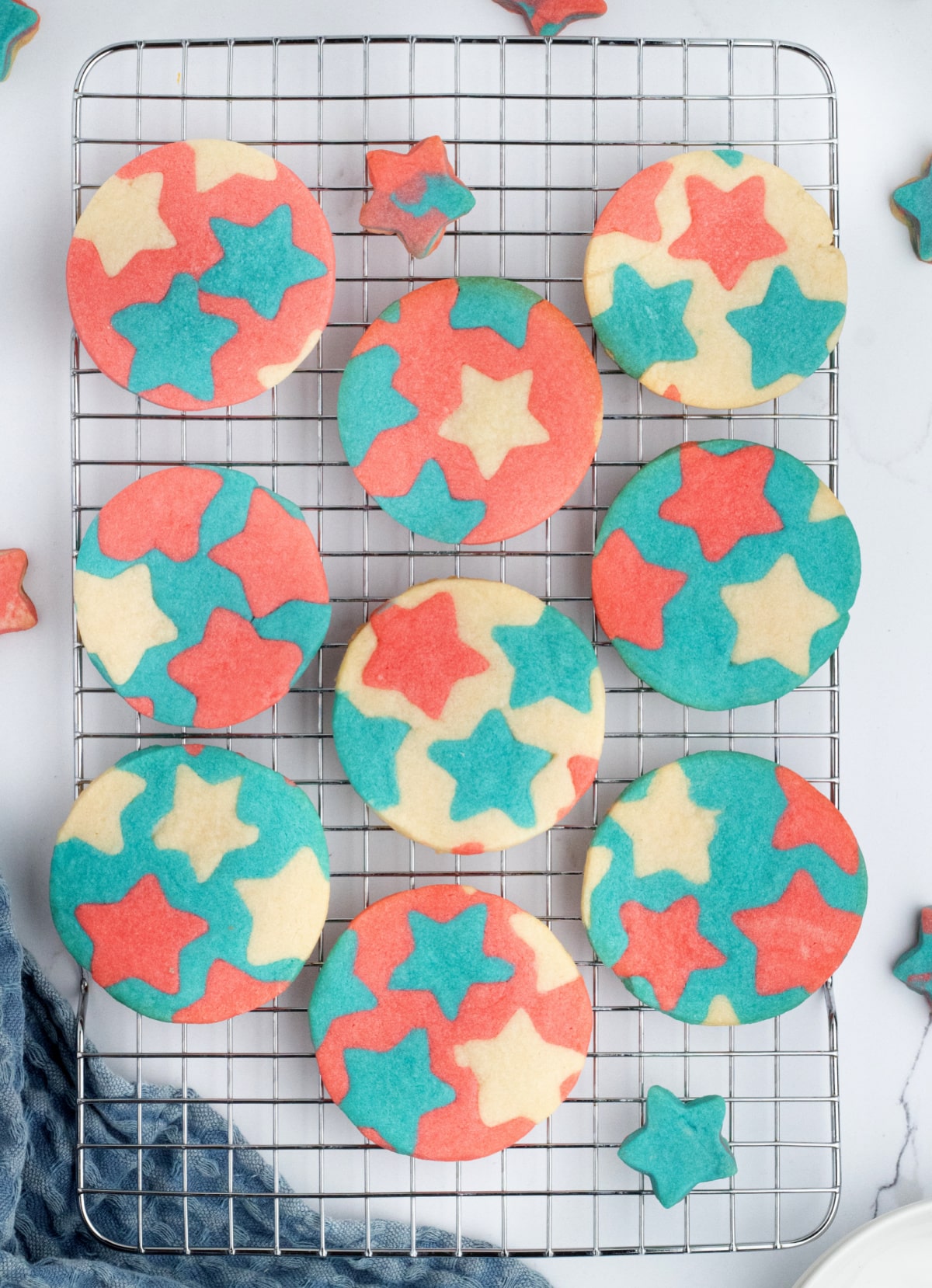 Colorful inlay star cookies on cooling rack Close-up of red, white, and blue butter cookies with bold inlay stars on a wire rack