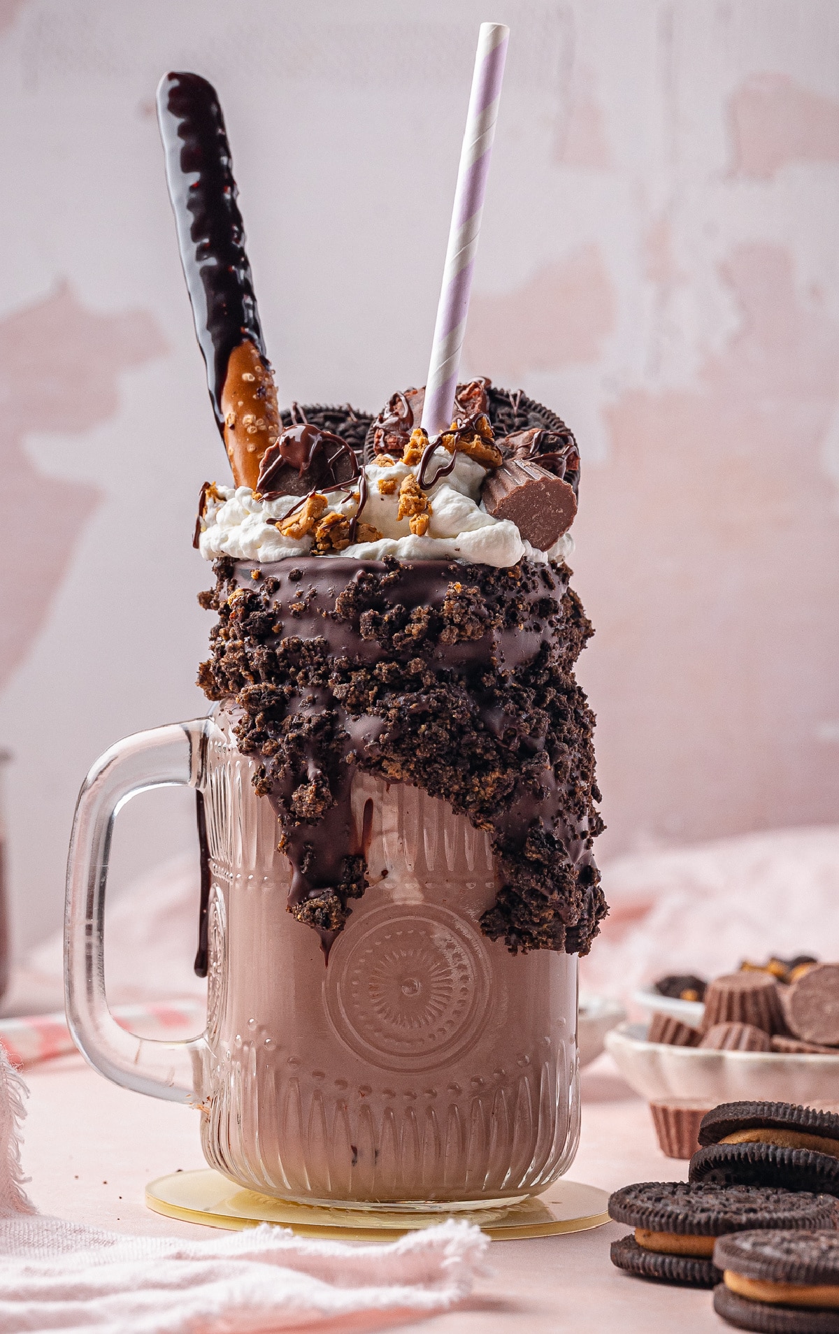 Ultimate chocolate freakshake with crunchy toppings and pink straw Freakshake with chocolate waffle, whipped cream, chocolate chips, and toffee rim