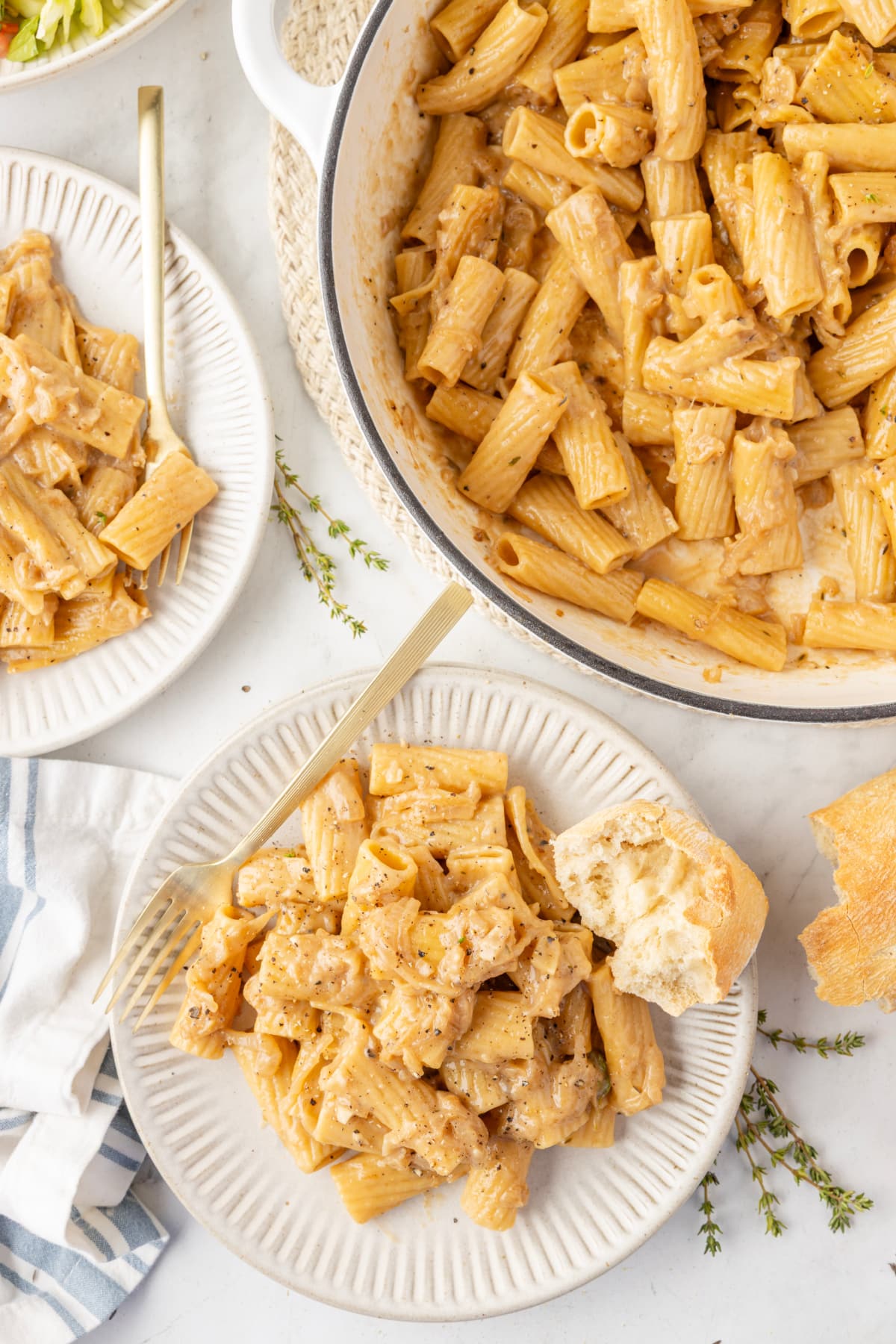 Weeknight-friendly French onion pasta dinner setup French onion pasta plated and served family-style with fresh bread and a side salad.