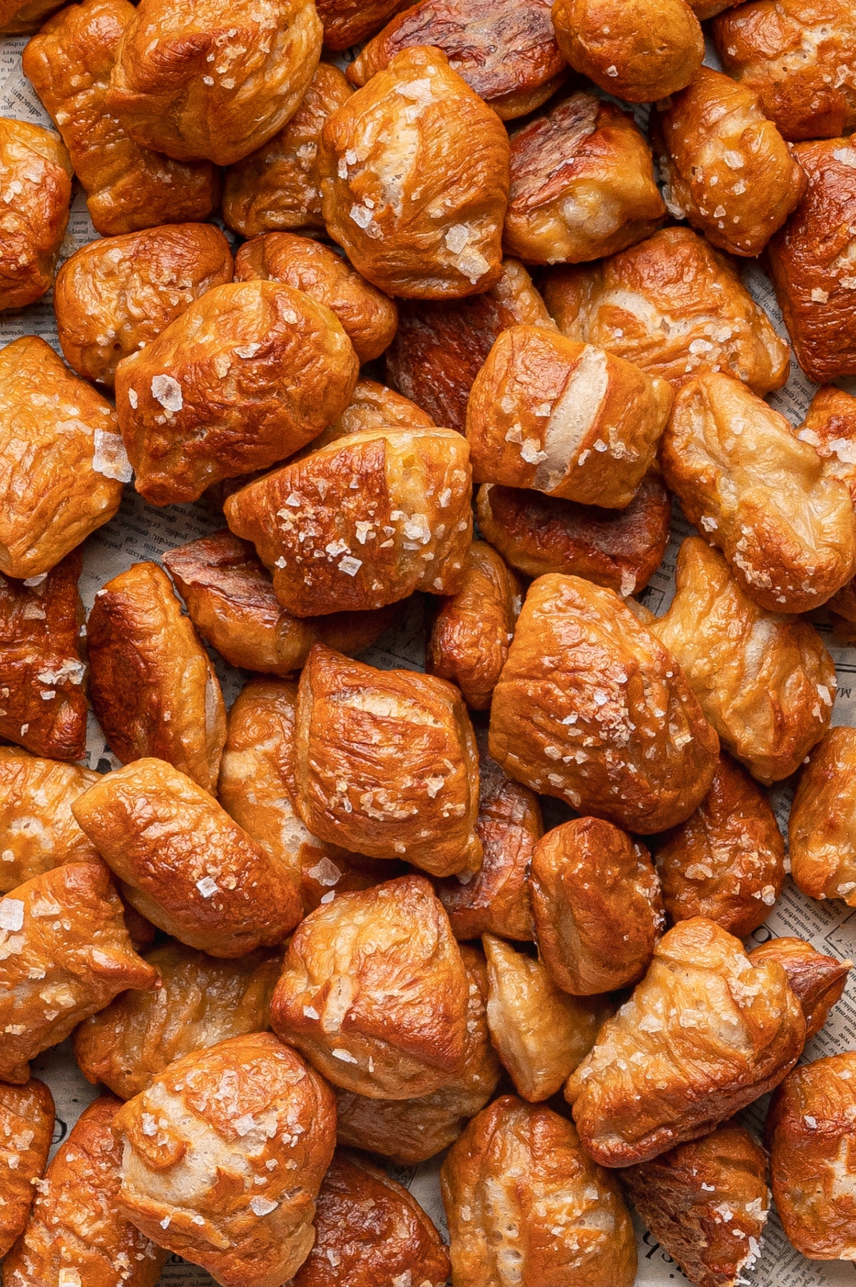 Homemade Soft Pretzel Bites on parchment, salty and golden brown golden homemade soft pretzel bites piled on parchment paper with coarse salt